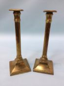 A pair of Doric column brass candlesticks