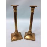 A pair of Doric column brass candlesticks