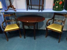 A Strongbow mahogany oval Pembroke table and a pair of carver chairs
