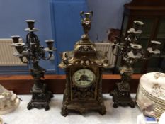 A late 19th century clock with 8 day movement, strike action and a pair of candelabra, 50cm height