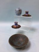 A Ruskin pottery shallow bowl, a small Ruskin pierced blue vase and a pair of candlesticks