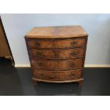 A walnut bow front chest of drawers