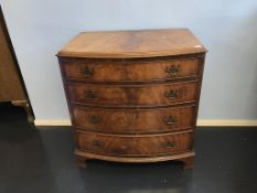 A walnut bow front chest of drawers