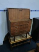 A teak fall front bureau and a tile top coffee table