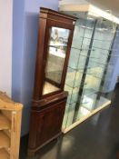 A reproduction mahogany corner cabinet