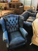 A blue leather Chesterfield three seater settee, a club chair and a high back armchair