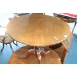 A mahogany tilt top tripod table