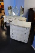 A cream chest of drawers, oak bureau and a dressing table