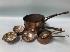A collection of copper pans and jelly moulds