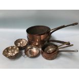 A collection of copper pans and jelly moulds
