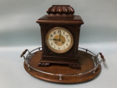An Edwardian walnut mantle clock and an oval oak tray