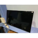 A Samsung 48", wall mounted TV, with remote