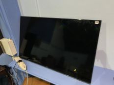 A Samsung 48", wall mounted TV, with remote