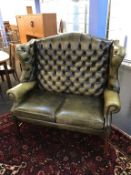 An olive green leather high back two seater Chesterfield settee