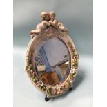 A German porcelain easel mirror, decorated with putti and encrusted flowers, 40cm height