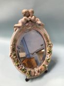 A German porcelain easel mirror, decorated with putti and encrusted flowers, 40cm height