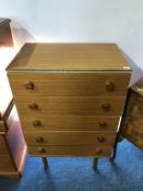 A teak chest of drawers