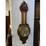 A carved oak banjo barometer