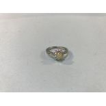 An 18ct white gold diamond ring, set with central yellow diamond, approximately 0.71ct, surrounded
