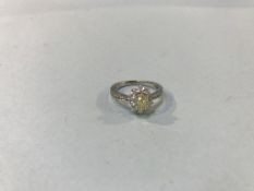 An 18ct white gold diamond ring, set with central yellow diamond, approximately 0.71ct, surrounded