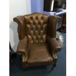 A brown leather Chesterfield high back armchair