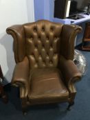 A brown leather Chesterfield high back armchair