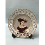 A German porcelain plate with pierced fretwork border, the centre decorated with a portrait of a