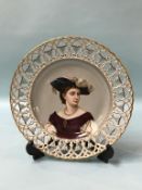 A German porcelain plate with pierced fretwork border, the centre decorated with a portrait of a