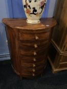 A half moon chest of seven drawers