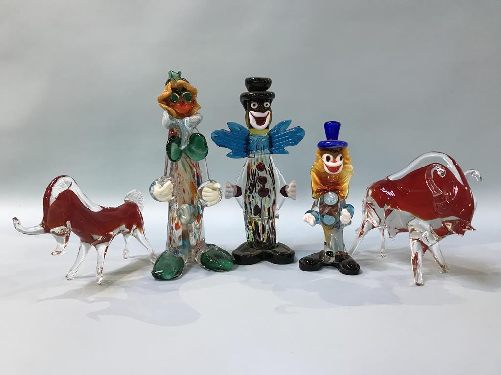 Two small glass bulls and three Murano glass clowns