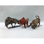 An amber coloured glass model of a bull and two metalwork models of bulls