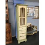A narrow painted kitchen cabinet in apple green and cream