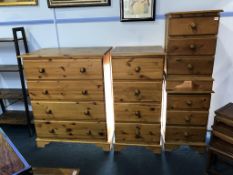 A large pine chest of drawers, a narrow pine chest of drawers and a pair of pine bedside chests