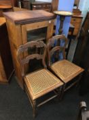 A glazed cabinet, pair of chairs and a plant stand