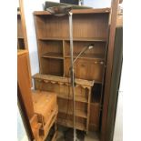 A teak bookcase, pine plate rack and a lamp