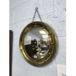 A circular brass framed mirror