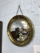 A circular brass framed mirror