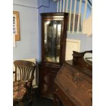 A reproduction mahogany corner cabinet