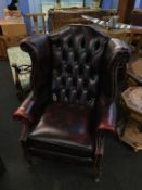 A maroon leather wing armchair