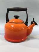 An orange Le Creuset kettle