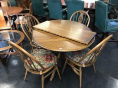 An Ercol extending dining table and four Windsor chairs