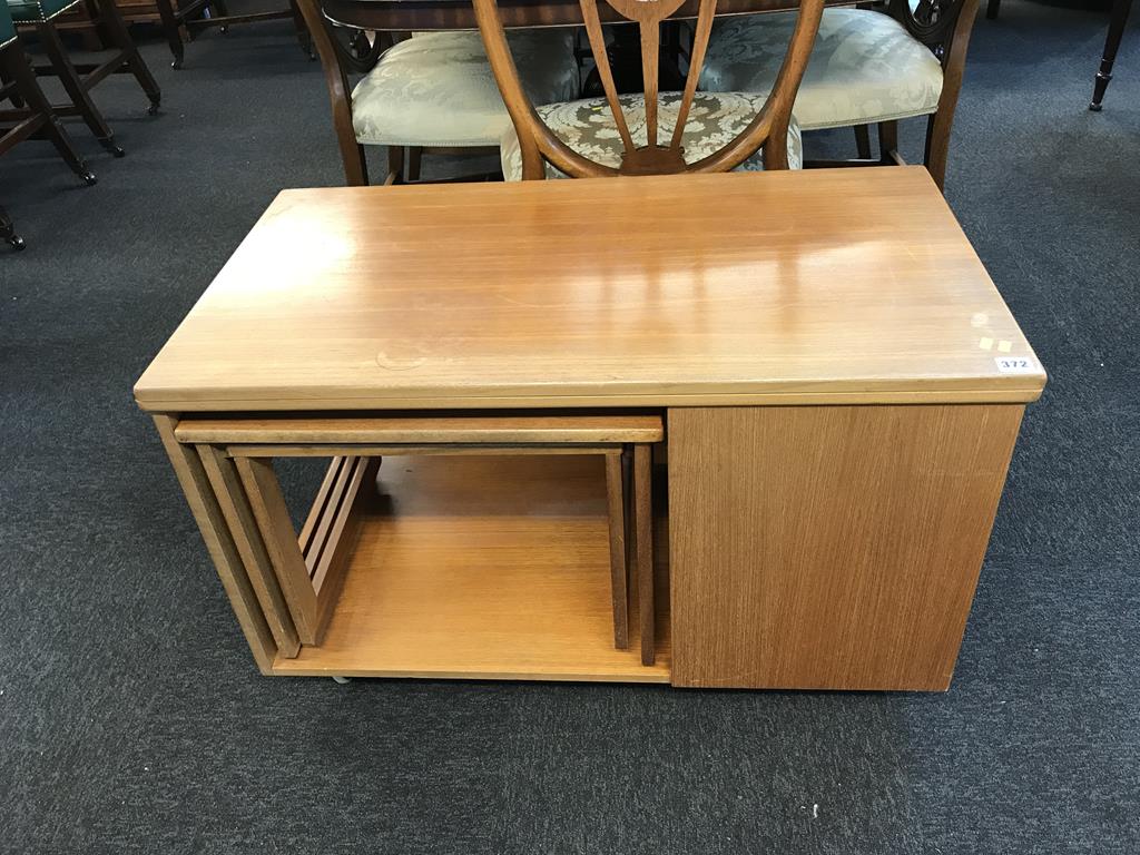 A teak fold over table, with nest of tables under