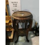 An Oriental hardwood pierced and carved two tier pedestal table, 56cm height x 32cm diameter