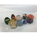 Nine various coloured glass paperweights