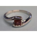 A 9ct white gold and garnet ring, size 'N'