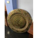 A very large and decorative Indian brass table top, decorated with a central peacock with stylised