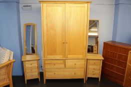 A light oak wardrobe, a pair of bedside chests and two mirrors