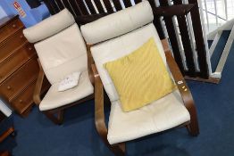 A pair of cream leather armchairs