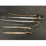 A collection of various swords, bayonets and a swagger stick