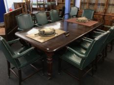 A mahogany extending dining table, with two extra leaves, and a set of ten green leather and studded